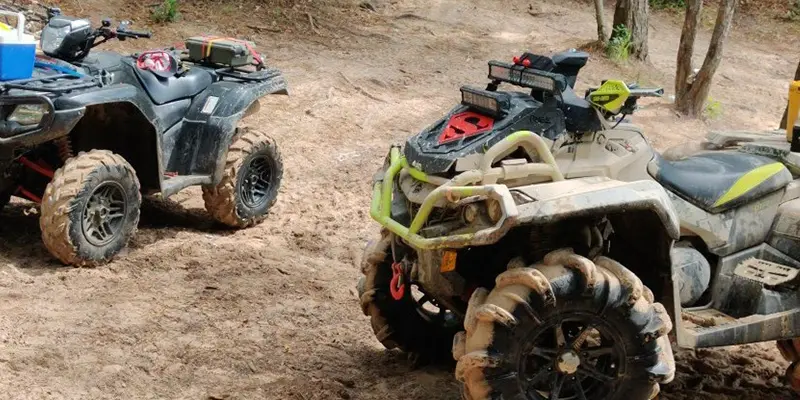 An ATV splashing dynamically through a large mud puddle at Creekside Offroad Ranch.